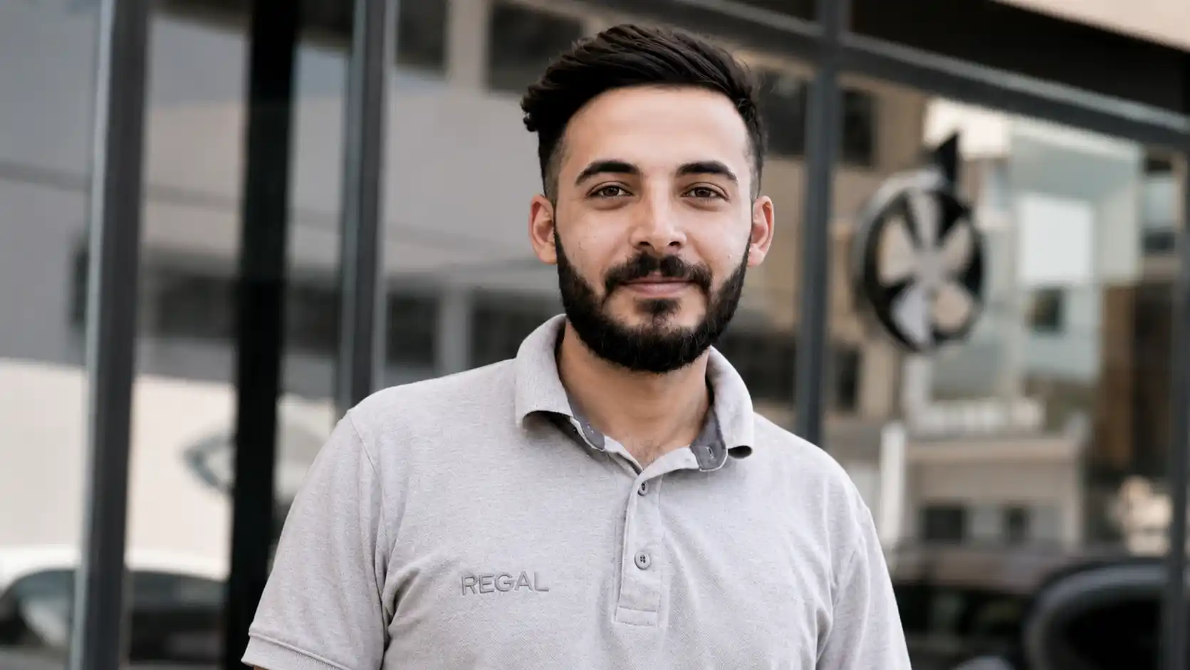 Portrait von Hogir Alay. Er hat kurze schwarze Haare, einen Bart und lächelt in die Kamera.